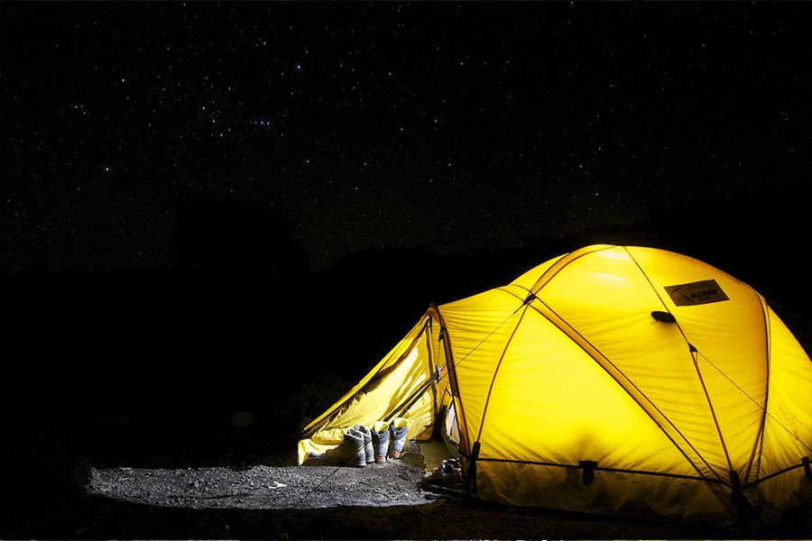 Carpa amarilla iluminada por una central eléctrica portátil