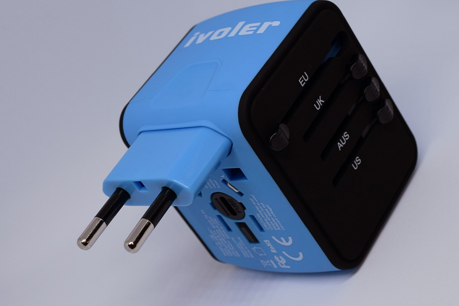 A blue universal travel adapter on a white background