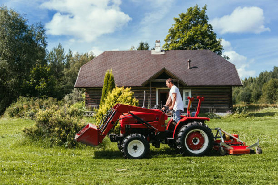 Ein Mann auf einem Traktor, der Gras schneidet