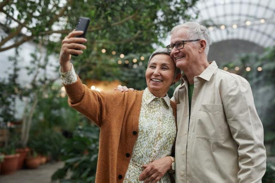 Ein älteres Paar klickt auf einem Smartphone auf ein Selfie