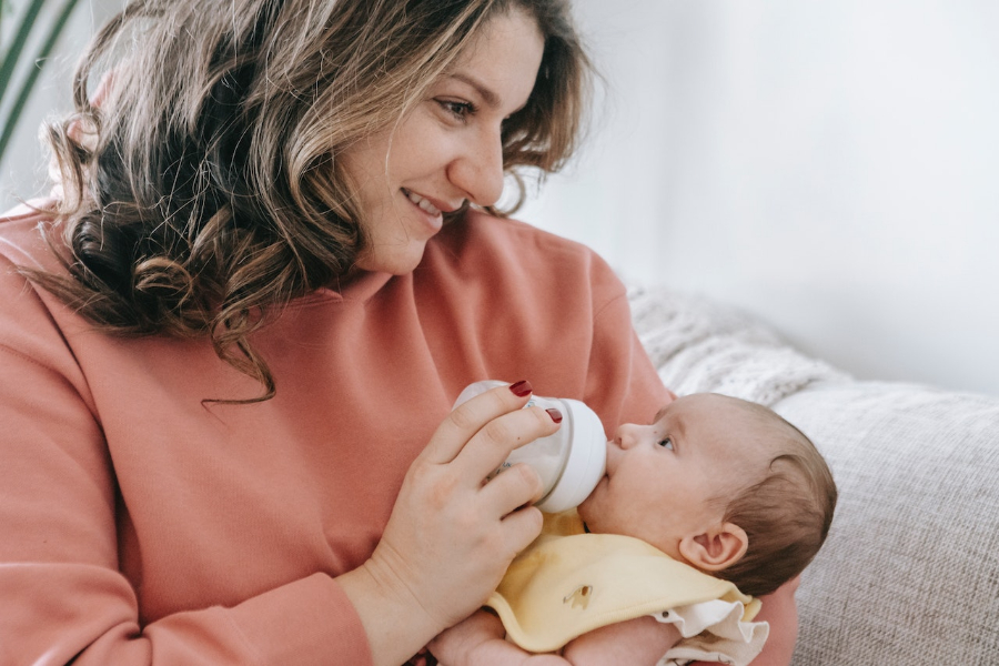 A woman feeding newborn baby