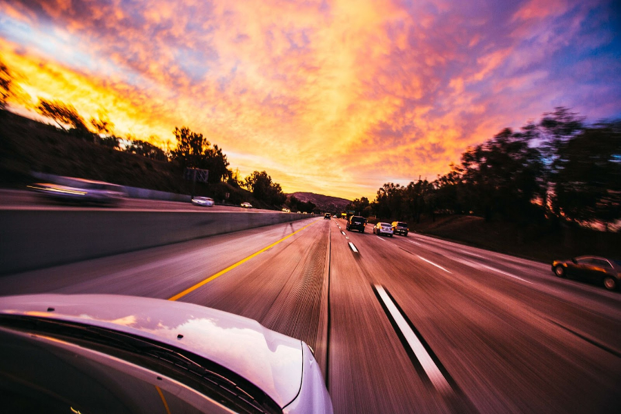 Guida in auto nel tramonto estivo