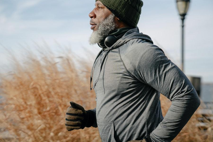 Homme à la peau foncée courant dans des vêtements de sport confortables