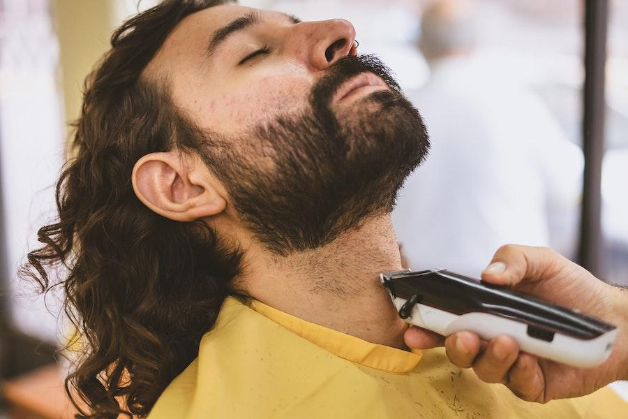 Uomo che si fa tagliare la barba da un tagliacapelli cordless