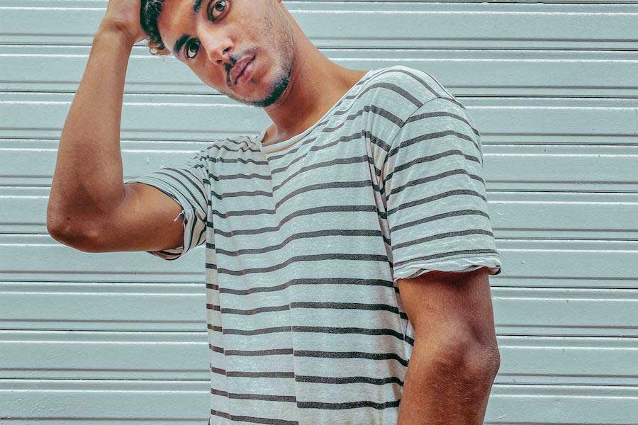 Hombre posando con camiseta náutica de rayas blancas y negras