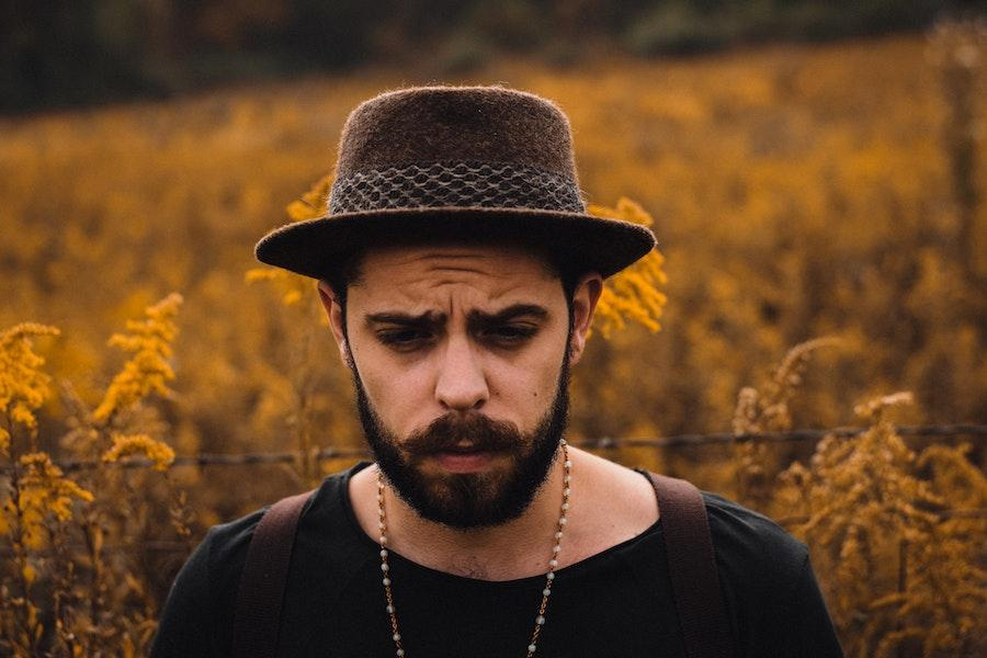 Uomo che dondola un cappello di feltro marrone