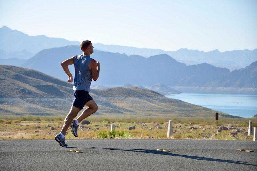 Homme qui court dans un débardeur bleu et un short noir