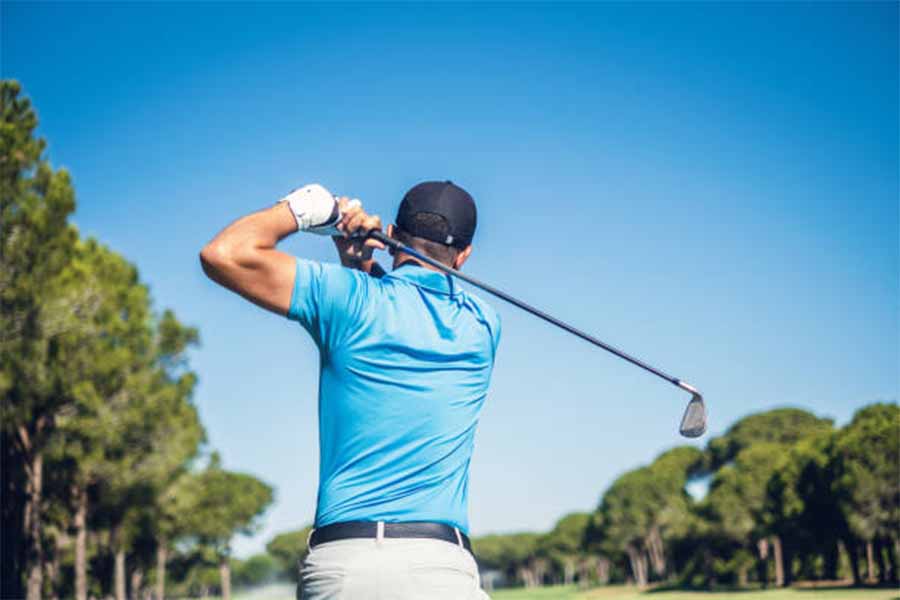 L'uomo tee off in un campo da golf in una giornata di sole