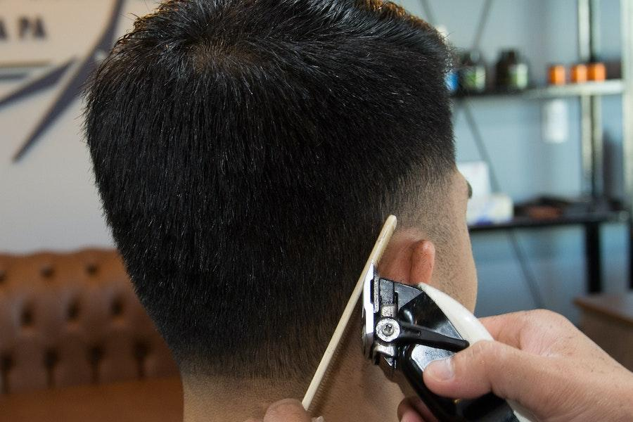 Uomo che usa un tagliacapelli normale per un taglio di capelli