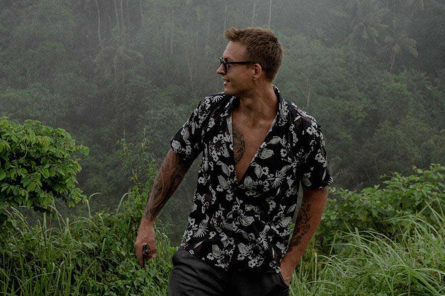 Hombre vestido con una camiseta negra con estampado de vacaciones