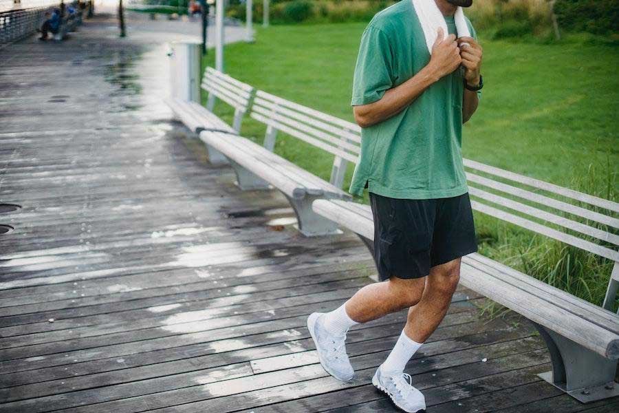 Homme portant une chemise ample verte et un short noir