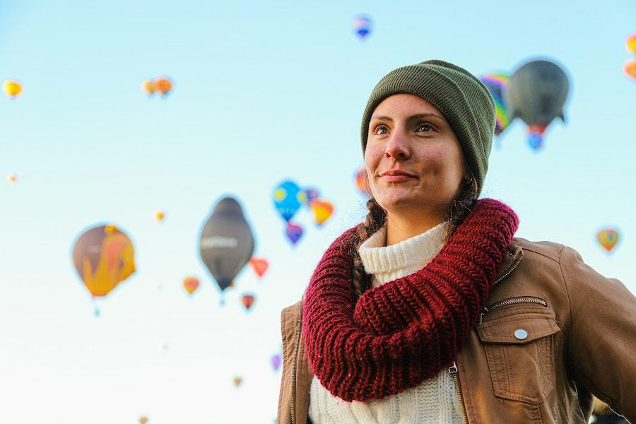 Bella donna che indossa un berretto verde e una giacca marrone