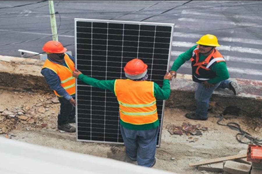 Instaladores solares segurando um painel solar