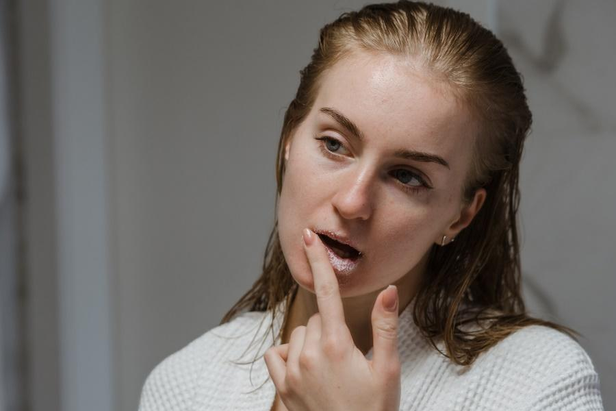 Woman applying exfoliating lip scrub