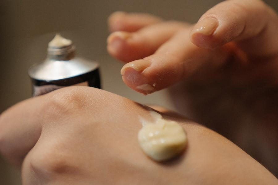 Mujer aplicando crema fermentada en las manos