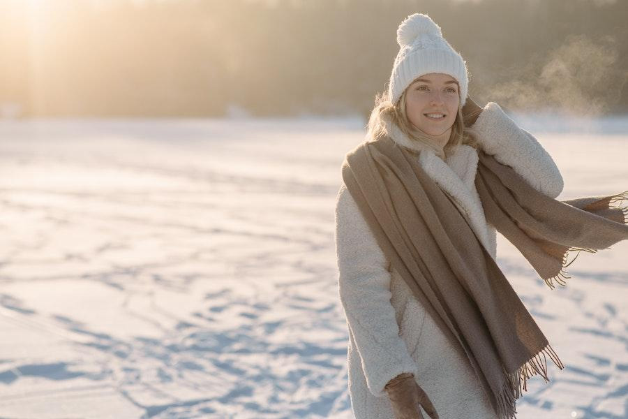 Mulher posando em um gorro de pom-pom branco