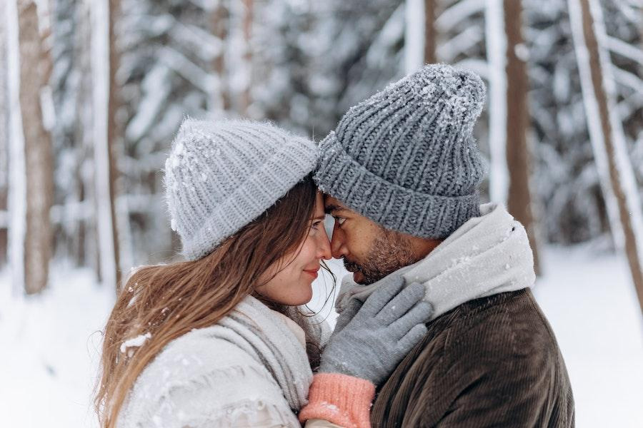 Mulher posando com um homem enquanto usava um gorro de caveira