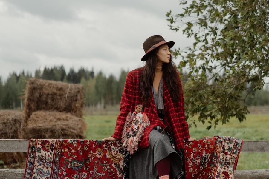 Mulher sentada em cima do muro com um chapéu de cowboy