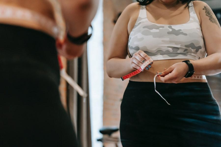 Femme portant un débardeur court camo et un bas noir