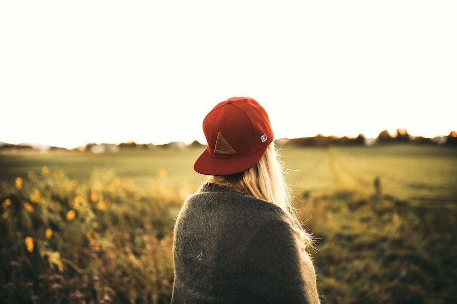 Donna che indossa un cappello da baseball rosso rivolto all'indietro