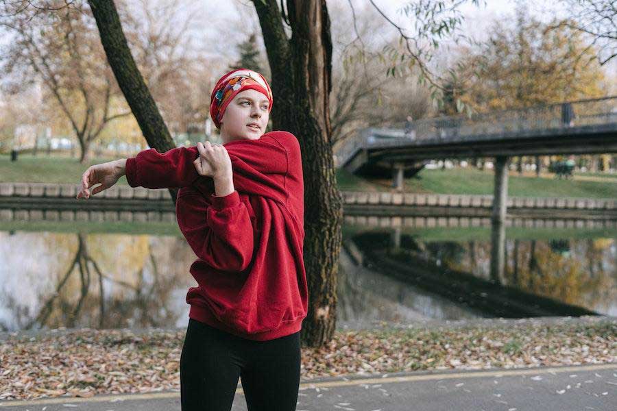 Woman wearing a red long-sleeve sweatshirt and black leggings