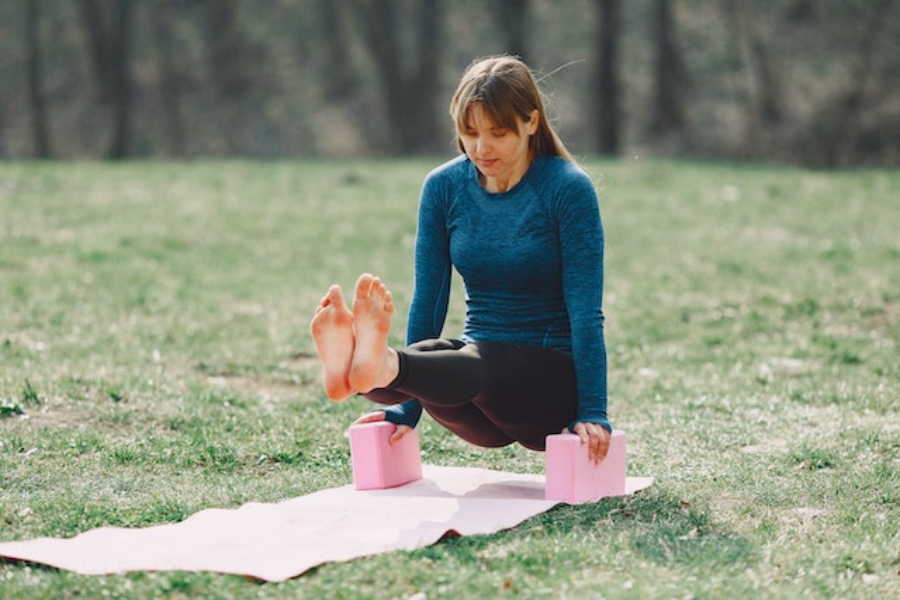 mujeres realizando ejercicios de yoga con bloques en un parque