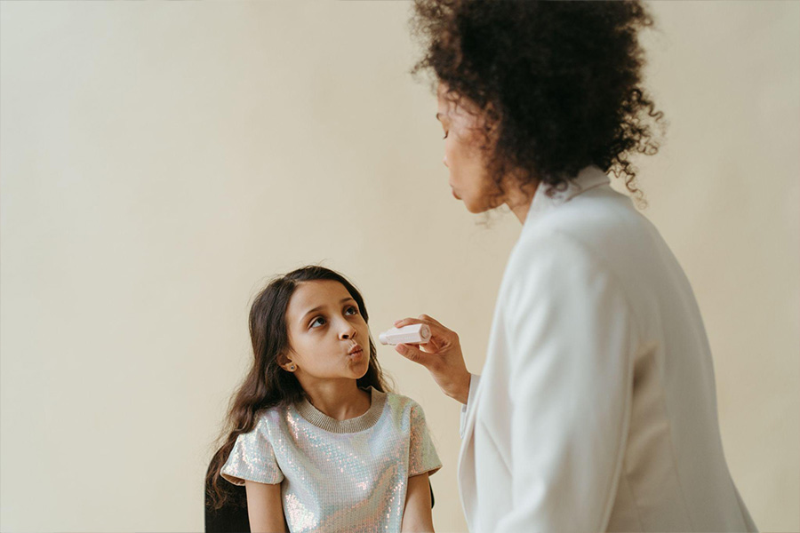 Women putting lipstick on a child