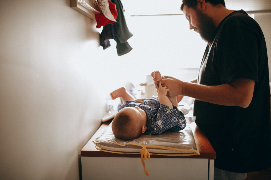 Jeune père changeant la couche du nouveau-né