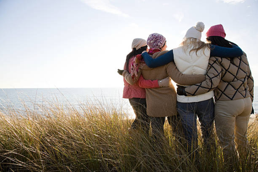 Un gruppo di donne vicino al mare che indossano diversi cappelli invernali