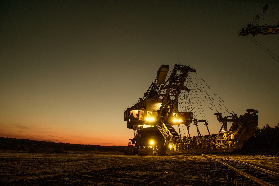 Een grote graafmachine draait 's nachts stationair