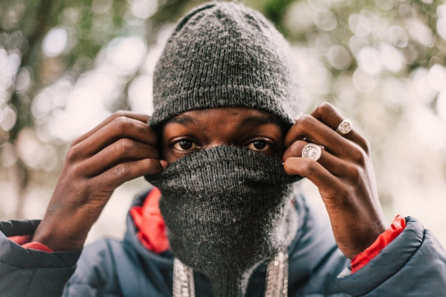 Um homem usando um chapéu balaclava de malha cinza