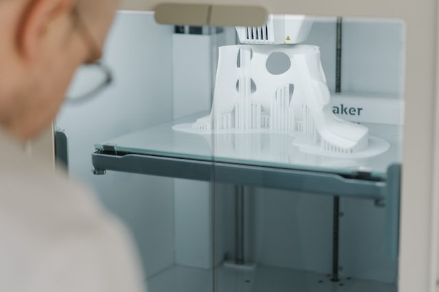 Eine Person steht neben einem 3D-Drucker