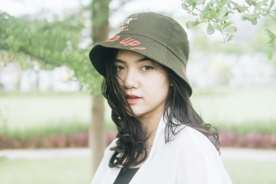 Uma mulher usando um chapéu bucket de sarja estampado verde militar