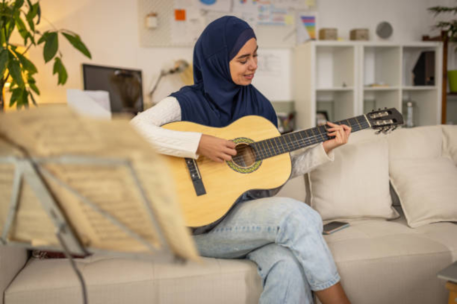 Akustik gitar çalan kanepede oturan kadın