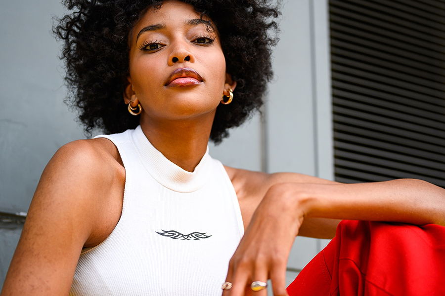 “Woman wearing elegant white tank top and red trousers